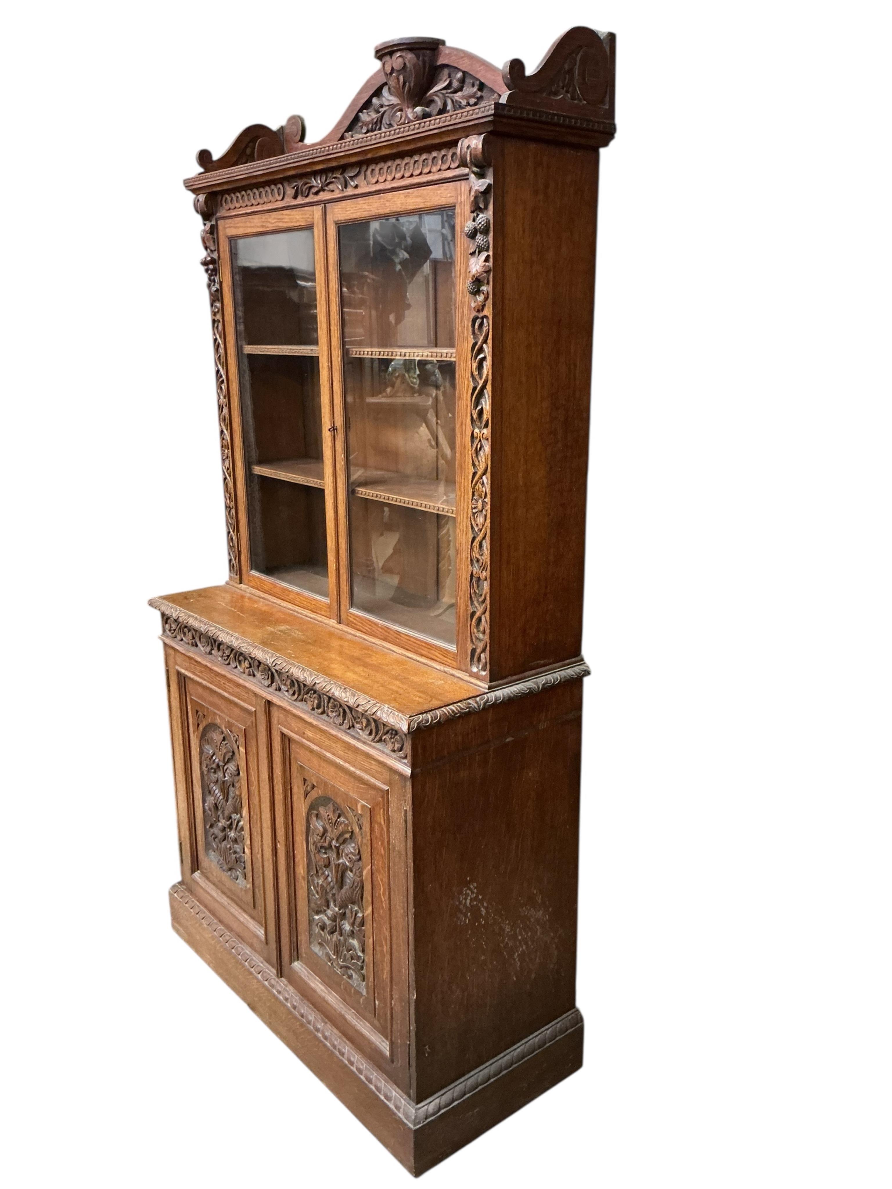 A late Victorian carved oak bookcase, width 90cm, depth 39cm, height 180cm